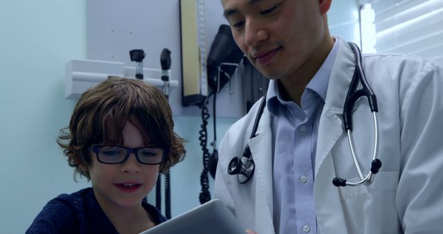 Doctor and Young Boy Interacting with Tablet in Medical Office - Download Free Stock Images Pikwizard.com