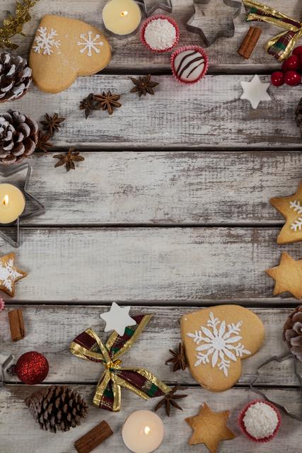 Christmas cookies with snowflake designs and various decorations arranged on a rustic wooden plank. Ideal for holiday greeting cards, festive invitations, seasonal blog posts, and social media content celebrating Christmas and winter holidays.