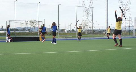 Female field hockey team scoring goal in competitive match