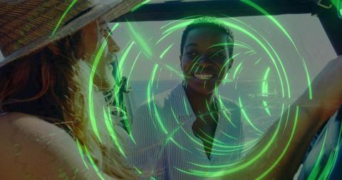 Smiling woman wearing striped shirt in car by ocean with straw hat and green hologram
