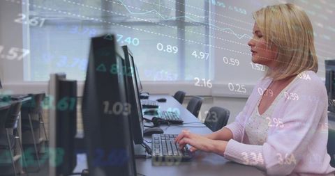 Focused woman typing at computer lab with overlaid financial data and analytics charts
