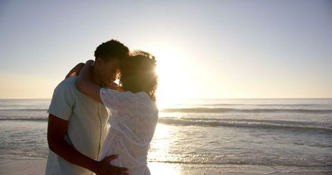 Tender Embrace of Couple at Beach During Sunset