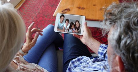 Elderly Couple Video Calling Family on Tablet at Home