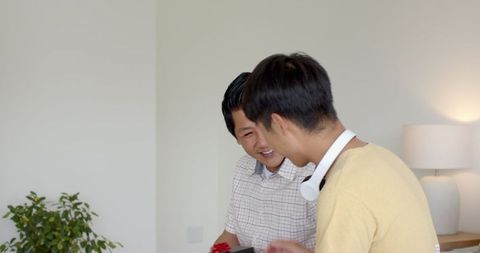 Father and Teenage Son Sharing Bonding Time with Tech Gadget
