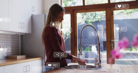 Young Woman Washing Hands in Kitchen with Virtual Social Media Icons