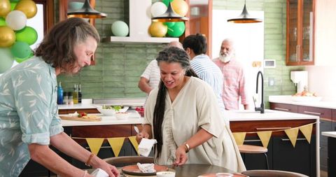 Seniors Enjoying Friendship and Table Preparation in Modern Kitchen
