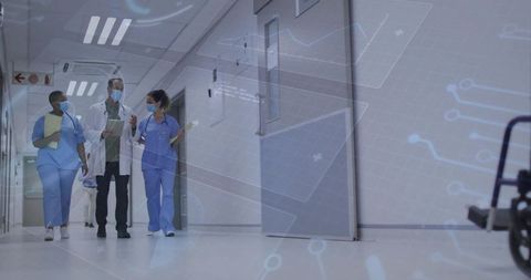 Medical team walking hospital corridor discussing care with digital health data overlay