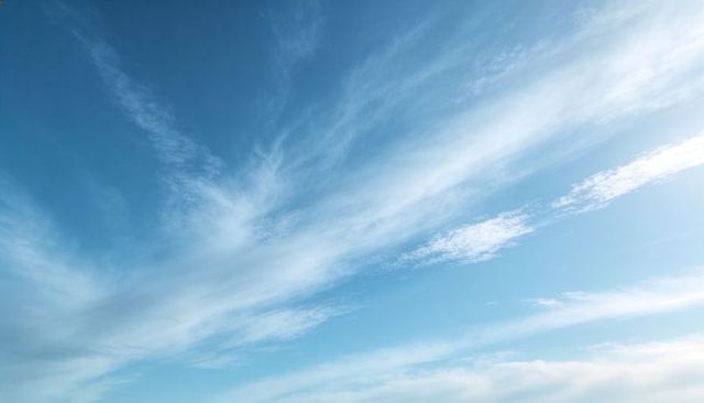 Wispy Cirrus Clouds Drifting Across Expansive Blue Sky with Soft Diagonal Streaks