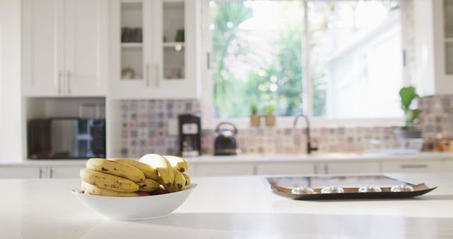 Close up of bowl of bananas lying on table in kitchen. Beauty, health and female spa home concept.