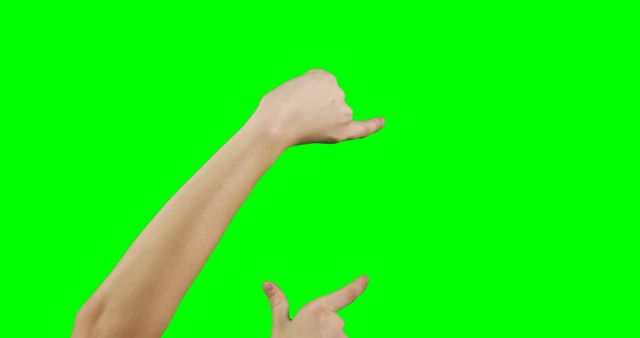 Hand gesturing in front of green screen background can be used in creative projects, visual effects, and promotional material. Ideal for graphic designers to overlay different content and create custom visual scenes.