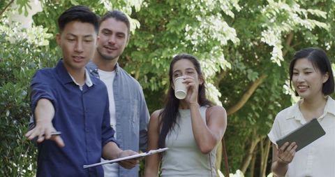 Diverse team discussing wedding plans outdoors with tech tools