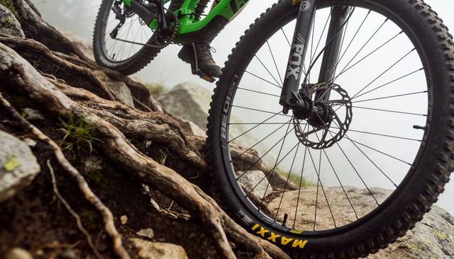 Riding mountain bike over roots and rocks with front wheel and suspension fork