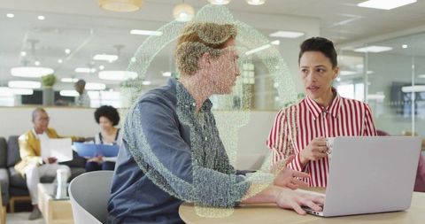 Collaborators discussing project at laptop with headset icon overlay in modern office