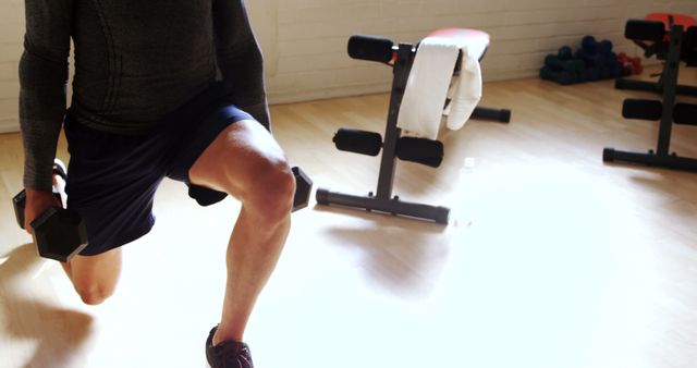 Man Doing Dumbbell Lunges in Sunlit Gym - Download Free Stock Images Pikwizard.com