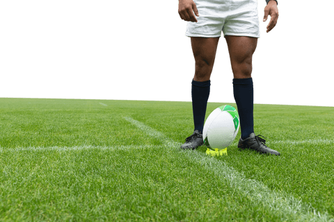 Rugby player stands ready on field with ball wearing white shorts
