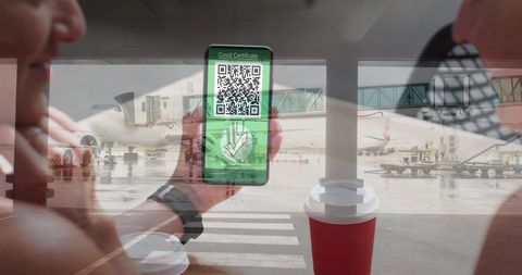 Smartphone displaying covid-19 passport at airport terminal