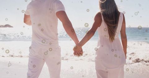 Couple Holding Hands on Tranquil Beach Day