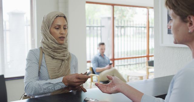 Woman with Hijab Making Payment Transaction at Reception - Download Free Stock Images Pikwizard.com