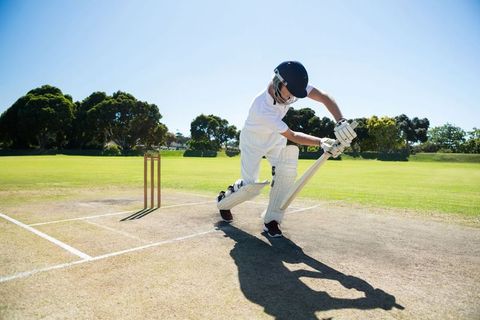 Batsman executing perfect cricket shot on sunny day