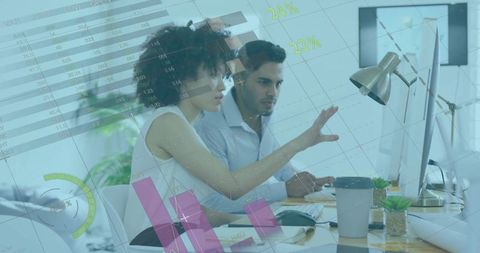 Business professionals analyzing data on monitors in office workspace