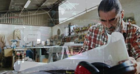 Focused Carpenter Analyzing Blueprints in Workshop with Digital Overlays