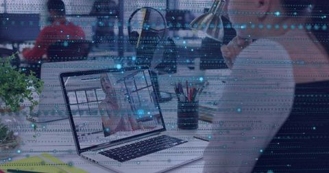 Woman Working on Laptop in Open-Plan Office with Digital Data Overlay