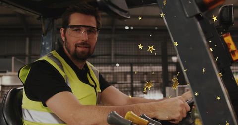 Forklift operator driving wearing hi-vis vest and safety glasses with gold stars
