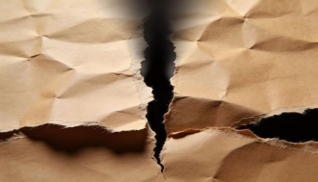 Crumpled Kraft Paper with Central Tear and Ragged Edges Macro Texture Background