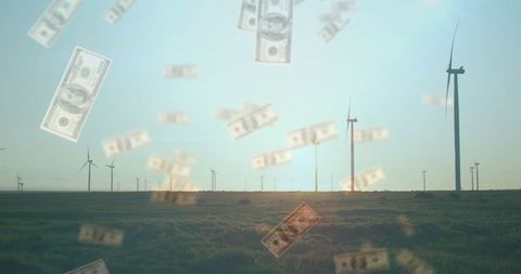 Falling dollar bills amidst wind turbines in field