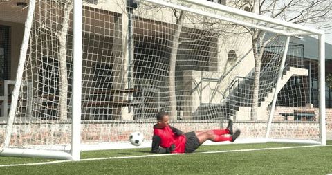 Goalkeeper Diving to Block Goal on Soccer Field