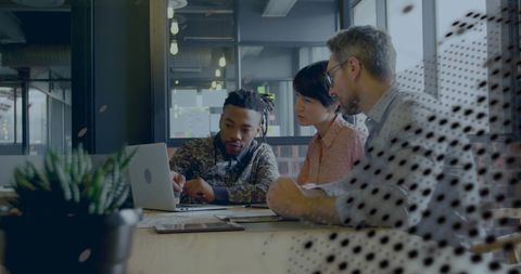 Collaborative Team Analyzing Business Data on Laptop