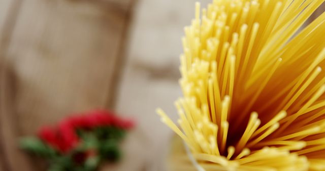 Close-up of Uncooked Spaghetti with Red Flowers in Background - Download Free Stock Images Pikwizard.com