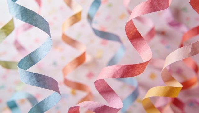 Colorful spiral crepe streamers cascading in soft bokeh for party celebration