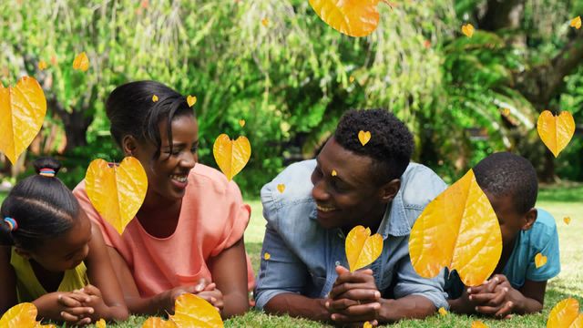 Family members are lying on grass, lovingly enjoying each other's company as animated yellow leaves fall around them. The lush green surroundings provide a serene ambiance, perfect for promoting themes of family, connection, and outdoor fun. Use for family-focused content or advertisements centered on togetherness and seasonal change.