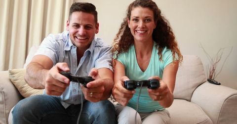 Happy Couple Playing Video Games Together on Couch
