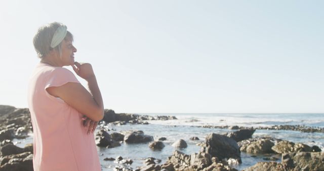 Contemplative Senior Woman Standing By Rocky Seashore - Download Free Stock Images Pikwizard.com