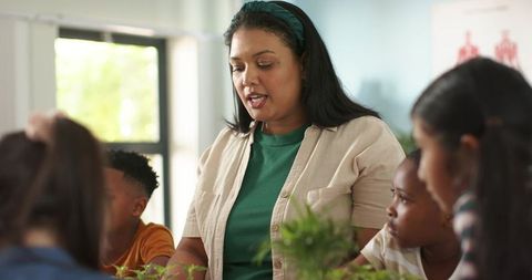 African american teacher guiding hands-on plant lesson with curious elementary students