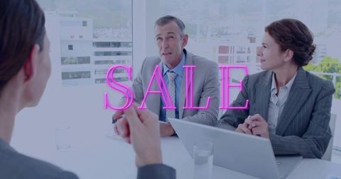 Neon sale overlay on corporate meeting: female presenter pitching to executives