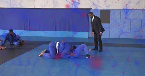 Grappling Training Session Wearing Blue Gis White Belts Coach Observing on Padded Mats