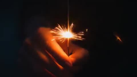Close-Up Hand Lighting Sparkler in Darkness, Slow Motion Spark Ignition and Warm Glow