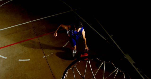 Athlete in action on a dark basketball court - Download Free Stock Photos Pikwizard.com