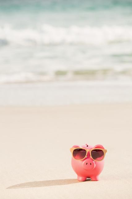 Piggy bank wearing sunglasses on sandy beach with ocean waves in background. Ideal for themes related to summer savings, vacation planning, financial advice, and travel expenses. Can be used for advertisements, blogs, social media posts, and financial planning articles.