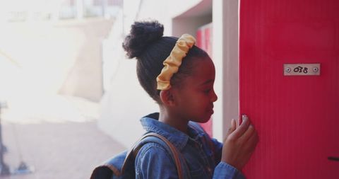 Schoolgirl opening locker at school courtyard