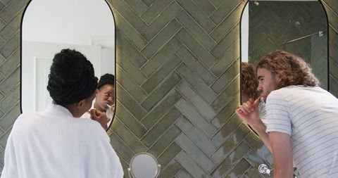 Diverse couple morning routine in modern bathroom