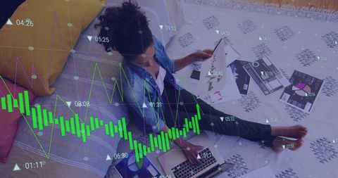 Businesswoman analyzing financial reports and graphs on laptop