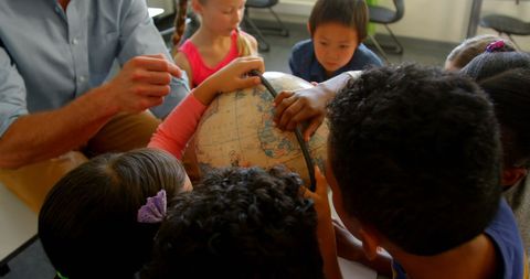 Diverse Children Engaged in Learning About Globe with Teacher