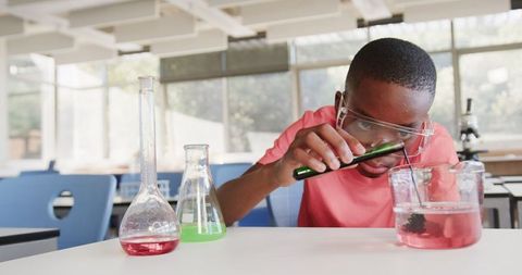 Curious student conducting science experiment in modern classroom