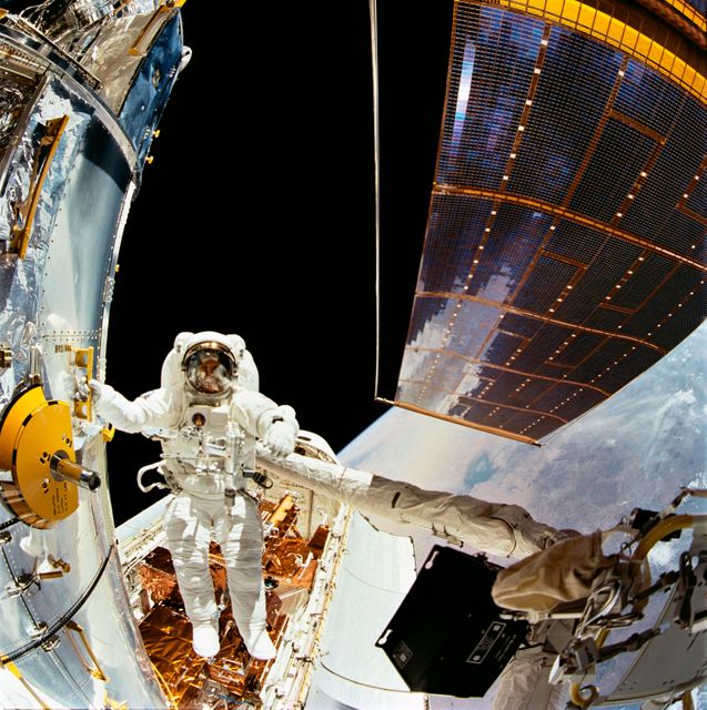 STS061-104-007 (5 Dec 1993) --- Astronaut F. Story Musgrave, holding to one of many strategically placed handrails on the Hubble Space Telescope (HST), is photographed during the first of five extravehicular activity?s (EVA) on the HST-servicing mission, aboard the Space Shuttle Endeavour.