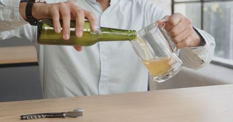 Pouring beer into mug for office celebration