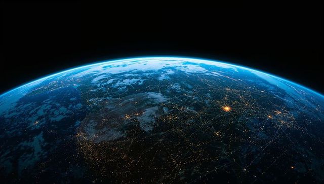 Earthlike world curving over horizon, city lights glowing under thin blue limb